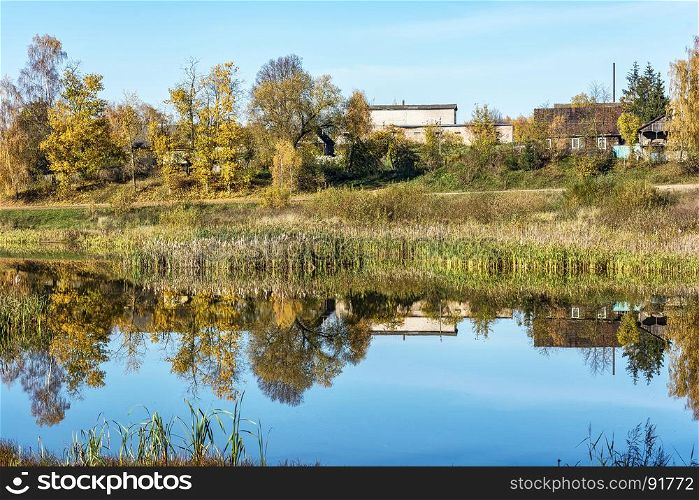 Autumn landscape. Countryside. Reflection in the surface of a pond