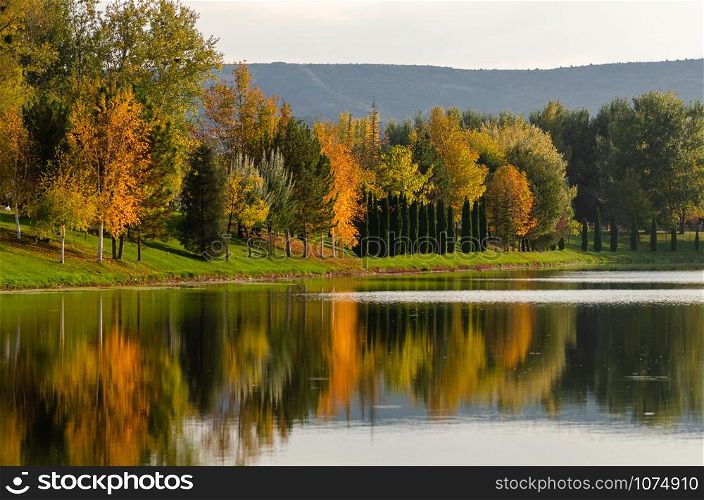 Autumn landscape .River with colorful leaves and reflection of trees. .Outdoor and nature.