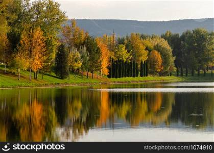 Autumn landscape .River with colorful leaves and reflection of trees. .Outdoor and nature.