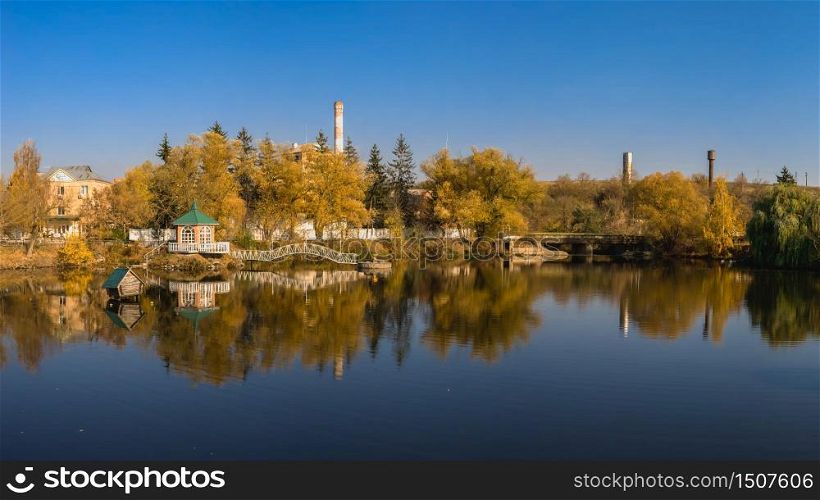 Autumn landscape with a lake and yellow trees in the village of Ivanki, Cherkasy region, Ukraine, on a sunny autumn evening. Autumn landscape with a lake and yellow trees