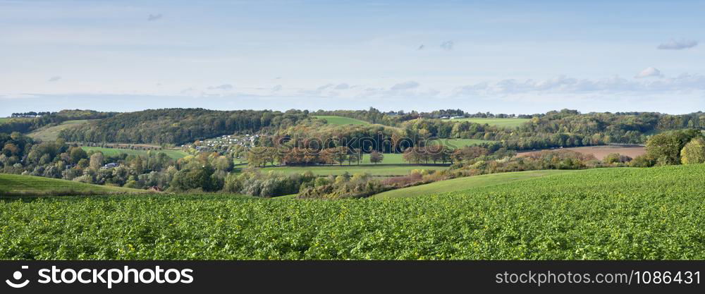 autumn landscape with fields and blue sky of south limburg near valkenburg in the netherlands under blue sky