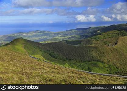 Autumn landscape with hills, yellow grass, forest and cloudscape on San Miguel island, Azores, Portugal&#xA;