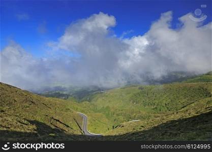 Autumn landscape with hills, yellow grass, road and cloudscape on San Miguel island, Azores, Portugal&#xA;