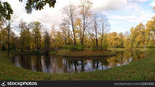 Autumn Landscape with lake and bridge in the colorful park