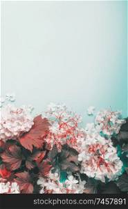Autumn leaves and flowers on light blue background, top view. Border. Copy space