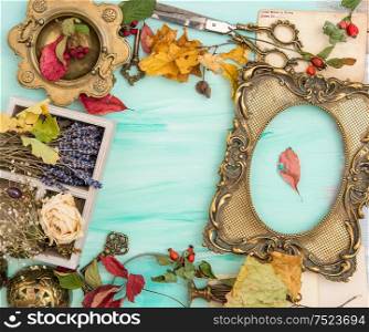 Autumn leaves and golden picture frame over bright wooden background. Scrapbook concept