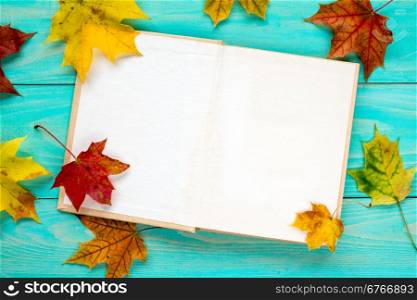 Autumn leaves and old book on the blue table