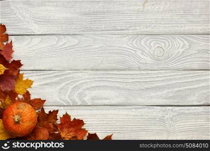 Autumn leaves and pumpkin over old wooden background . Autumn leaves and pumpkin over old wooden background with copy space