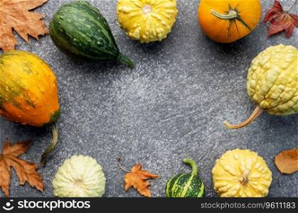 Autumn leaves and pumpkins over dark background