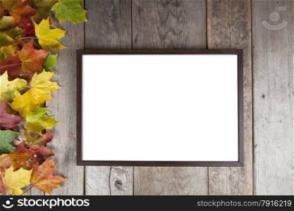 Autumn leaves annd frame on wooden background