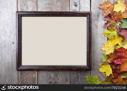 Autumn leaves annd frame on wooden background