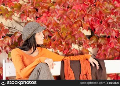 Autumn leaves park scenery young woman relax sitting on bench