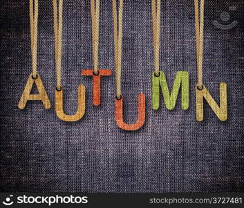 Autumn letters hanging strings with blue sackcloth background.. Autumn