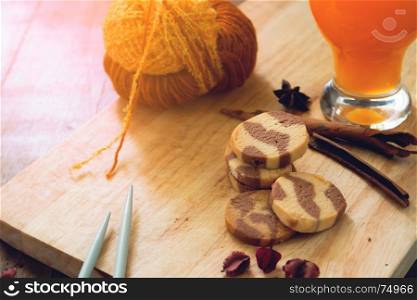 Autumn lifestyle concept with a cookies, orange juice and knitting, Lifestyle concept in warm color tone