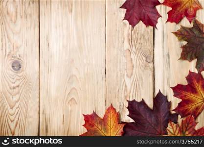 Autumn maple leaves on wooden background with copy space. Top view