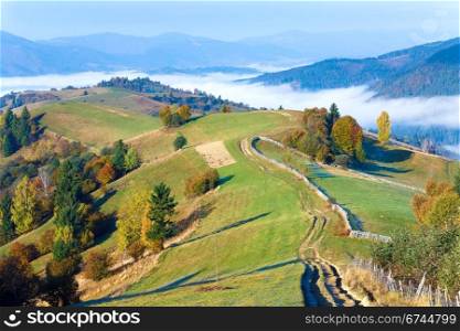 Autumn misty morning mountain view and country dirty road (Mighgirya village outskirts, Carpathian Mt&rsquo;s, Ukraine).