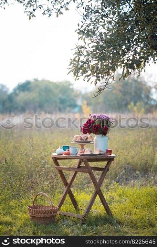 autumn mood. tea in the garden. apple pie, tea, aster bouquet and pumpkin decor 