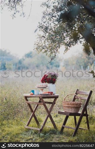 autumn mood. tea in the garden. apple pie, tea, aster bouquet and pumpkin decor 