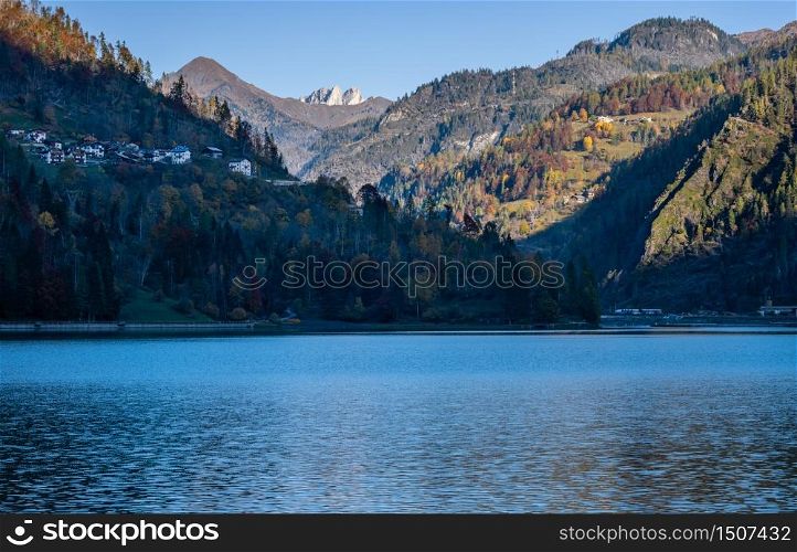 Autumn morning alpine Dolomites mountain lake Alleghe, Belluno, Sudtirol, Italy. Picturesque view from Alleghe village park Rusech.