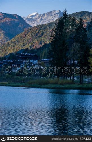 Autumn morning alpine Dolomites mountain lake Alleghe, Belluno, Sudtirol, Italy. Picturesque view from Alleghe village park Rusech.
