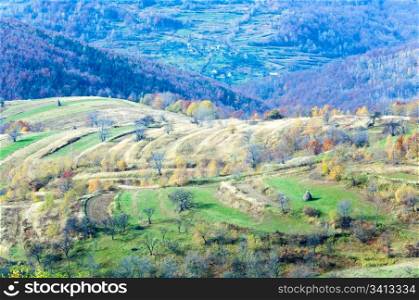 Autumn mountain country landscape with haystacks on hill (Carpathian, Ukraine).