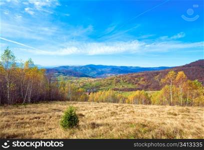 Autumn mountain country landscape with village ,birch trees and vapour trail in sky(Carpathian, Ukraine).