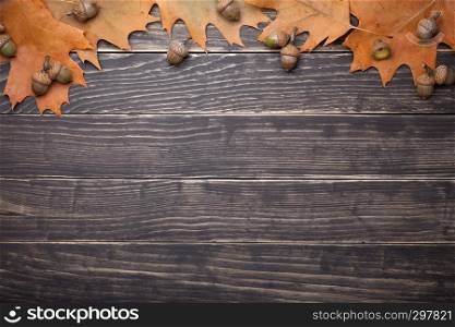 Autumn oak leaves and acorns on wooden table. Copy space. Top view
