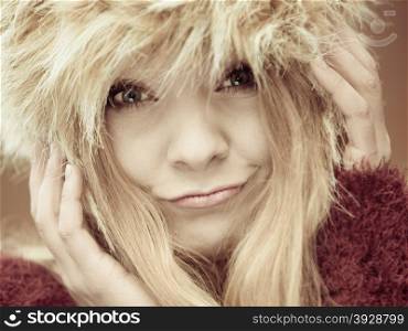 Autumn or winter fashion. Closeup happy young woman wearing fashionable wintertime clothes fur cap outdoor portrait