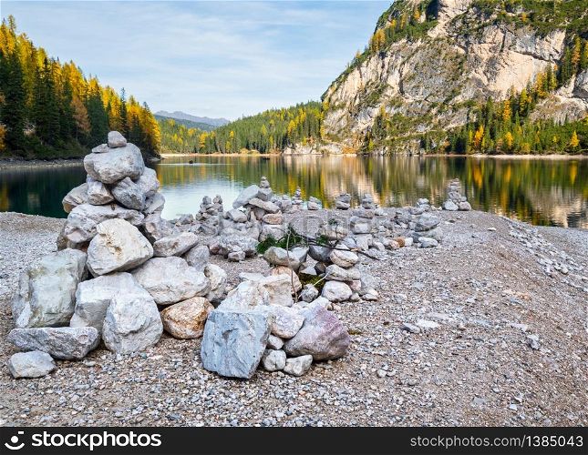 Autumn peaceful alpine lake Braies or Pragser Wildsee, South Tyrol, Dolomites Alps, Italy, Europe. People unrecognizable. Picturesque traveling, seasonal and nature beauty concept scene.