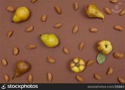 Autumn pear and nut pattern on brown background top view horizontal