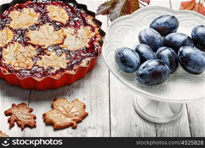 Autumn plum tart. Autumn pie with plum decorated cakes in the form of leaflets
