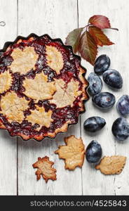 Autumn plum tart. Autumn pie with plum decorated cakes in the form of leaflets