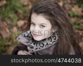 Autumn portrait of a beautiful young girl on the street