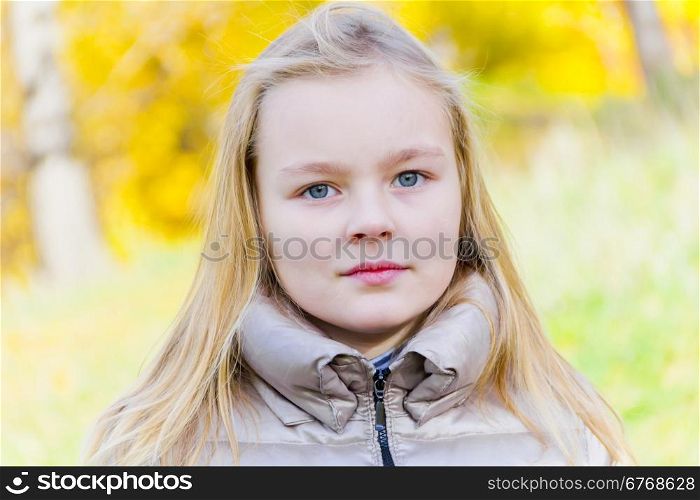 Autumn portrait of blond girl in sunlight