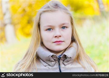 Autumn portrait of blond girl in sunlight