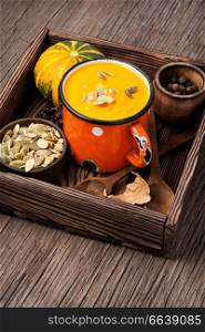 Autumn pumpkin soup in a metal cup. Autumn food. Pumpkin cream soup in mug