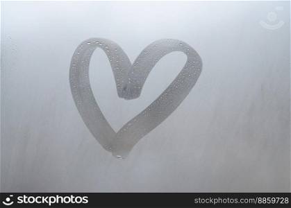 Autumn rain, the inscription on the sweaty glass - love and heart. Soft and beautiful background image with copy space