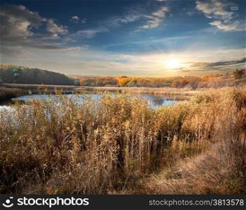 Autumn river and reeds and cloudy sky