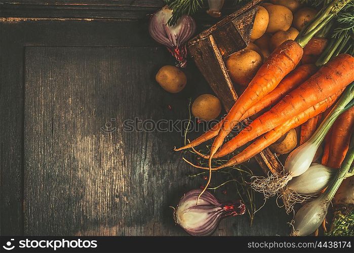 Autumn root vegetables cooking ingredients in wooden box on dark rustic background, top view, place for text, top view