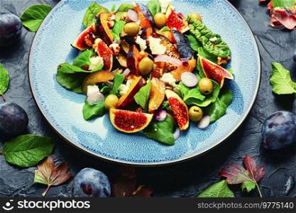 Autumn salad with figs, plums and herbs.Healthy food. Vitamin salad with fruit, olives and herbs