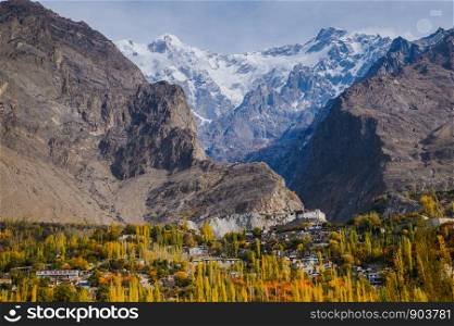 Autumn scene in Hunza valley with a view of Baltit fort and snow capped Ultar sar mountain in Karakoram range in the background. Karimabad, Hunza, Gilgit Baltistan, Pakistan.