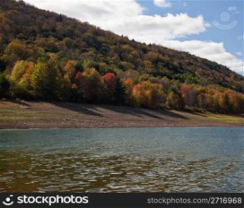 Autumn scene in Vermont as leaves are reflected in calm river