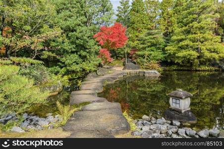 Autumn scenery with red maple trees and pond of Kokoen garden in Himeji, Japan