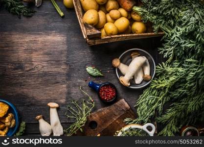 Autumn seasonal cooking ingredients with harvest vegetables, greens , Potatoes and mushrooms on dark rustic kitchen table background, top view, place for text, border
