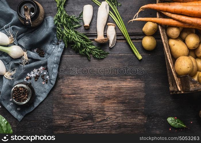 Autumn seasonal cooking ingredients with harvest vegetables, greens , Potatoes and mushrooms on dark rustic wooden background, top view, place for text, border