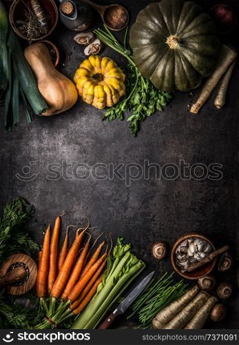 Autumn seasonal food background with colorful various pumpkins and organic farm vegetables on dark kitchen table, top view. Healthy vegetarian cooking. Thanksgiving or Halloween recipes. Seasonal