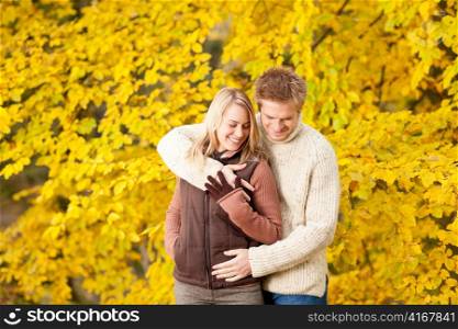 Autumn smiling young couple in love hugging in park together