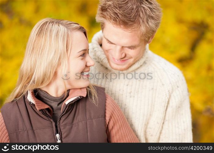 Autumn smiling young couple in love hugging in park together
