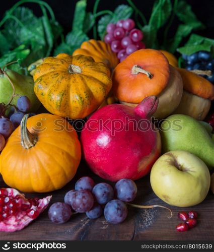 Autumn still-life with lots of different fruits and vegetables on the dark wooden background