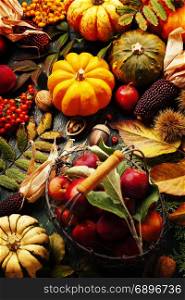 Autumn still life with pumpkins, apples and leaves on old wooden background